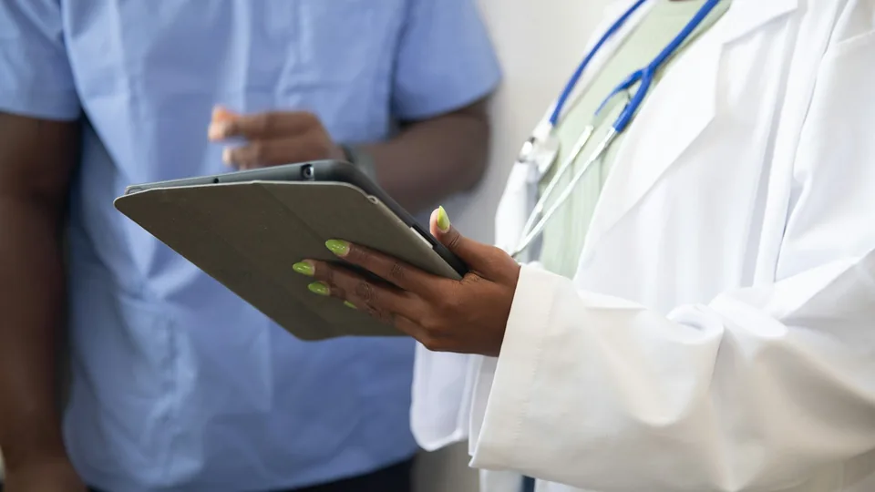 Médecin expliquant une couverture santé à un patient sur une tablette