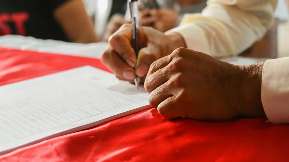 Main signant une attestation sur papier libre