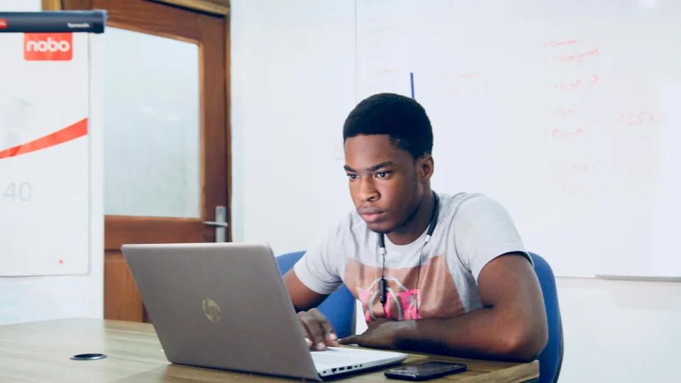 Étudiant comparant deux procédures d'inscription sur son ordinateur