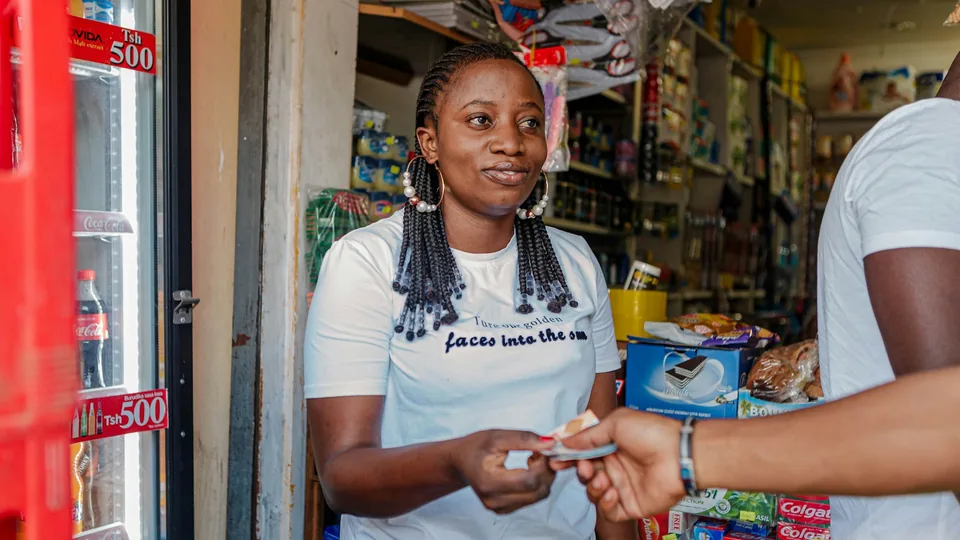 Jeune femme réglant un achat depuis son téléphone en boutique